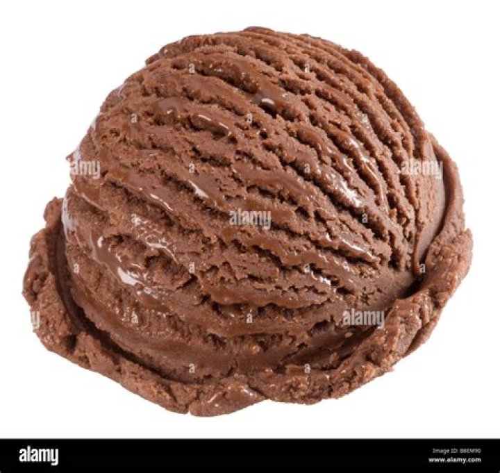 Closeup of a scoop of cookie dough ice cream in a white bowl.