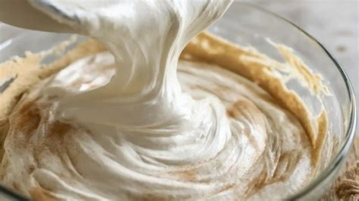 Cream cheese filling being poured into a pie crust.