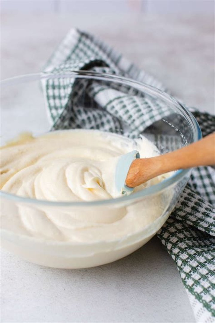 Cream cheese frosting in a glass bowl.
