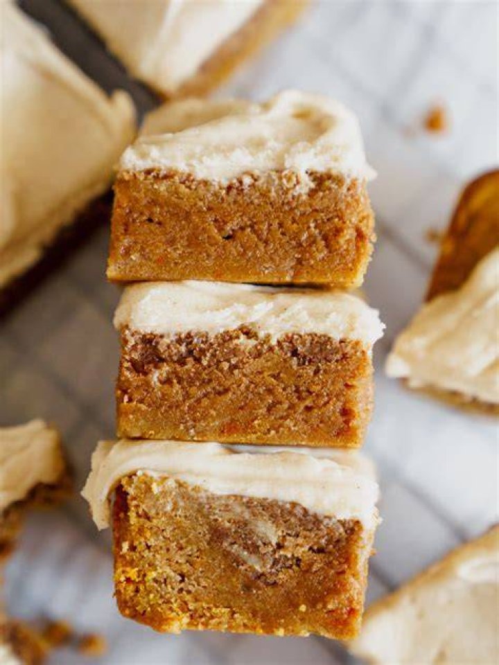 Frosting being spread onto blondie bars.