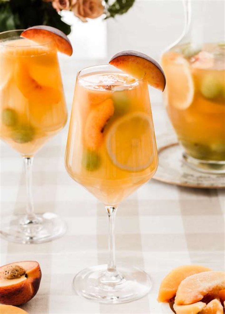 Peach Sangria in a glass pitcher.