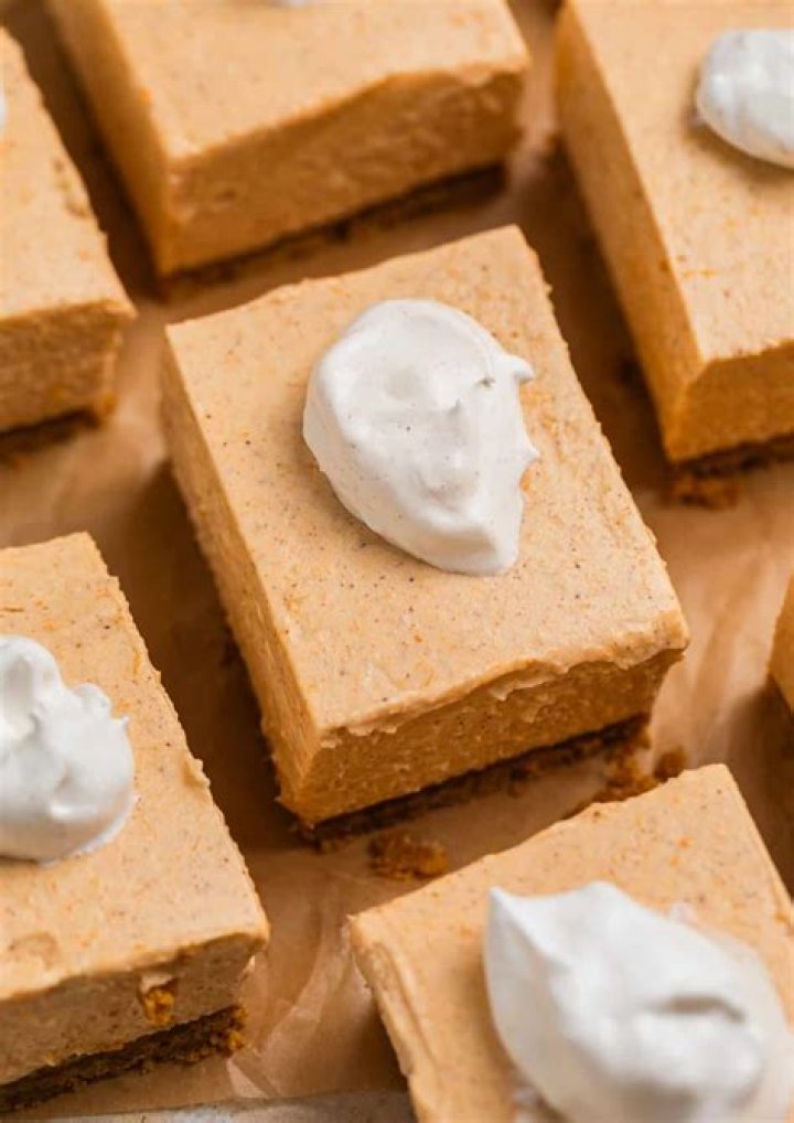 Pumpkin cheesecake bars on parchment paper.