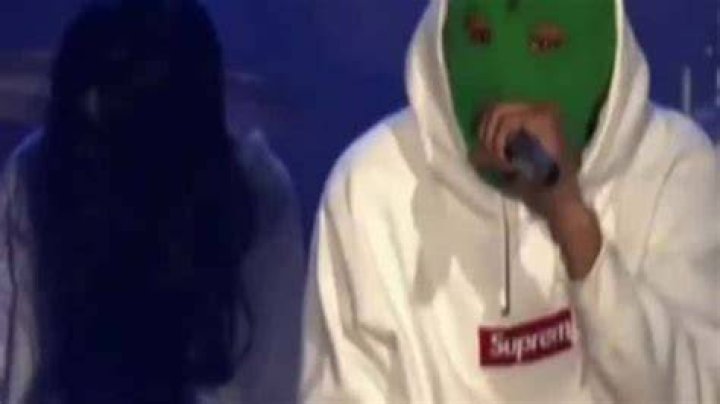 Rapper Hodgy singing at a concert topless.