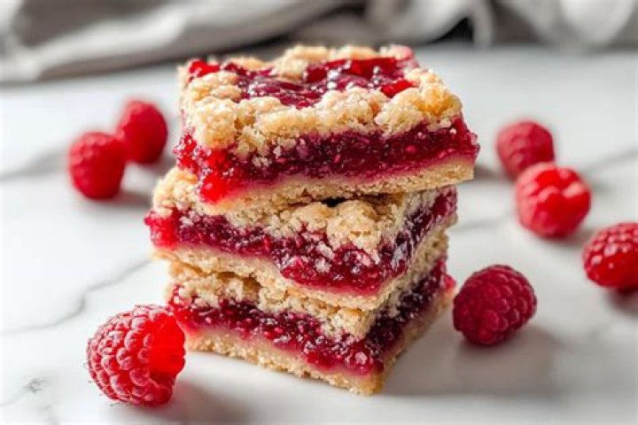 Raspberry bar on a plate topped with vanilla ice cream.