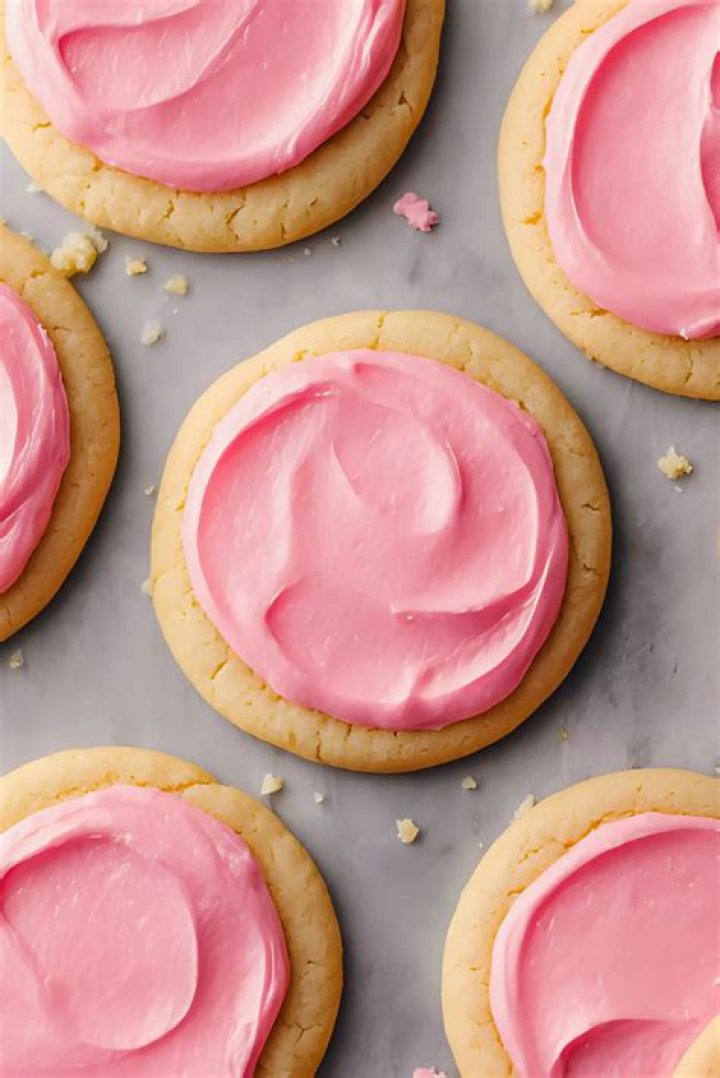 Sugar cookies topped with pink strawberry frosting.