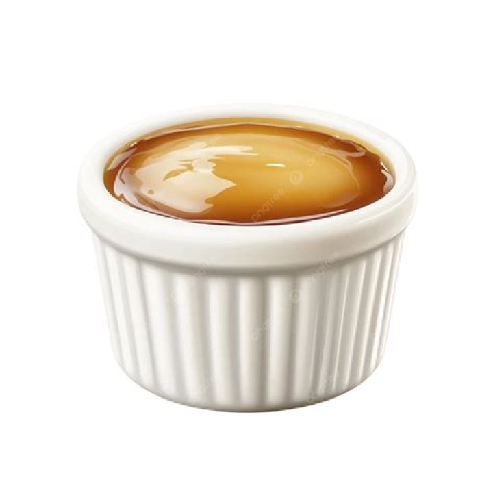 Vanilla pudding in a white ramekin with berries.